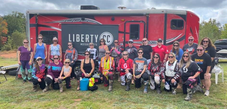 Women In Moto participants in front of Liberty CC banner