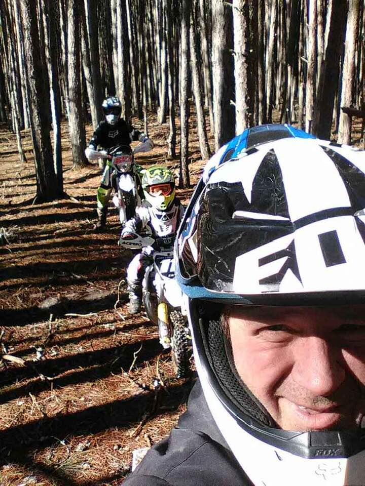 Family dirt biking in woods
