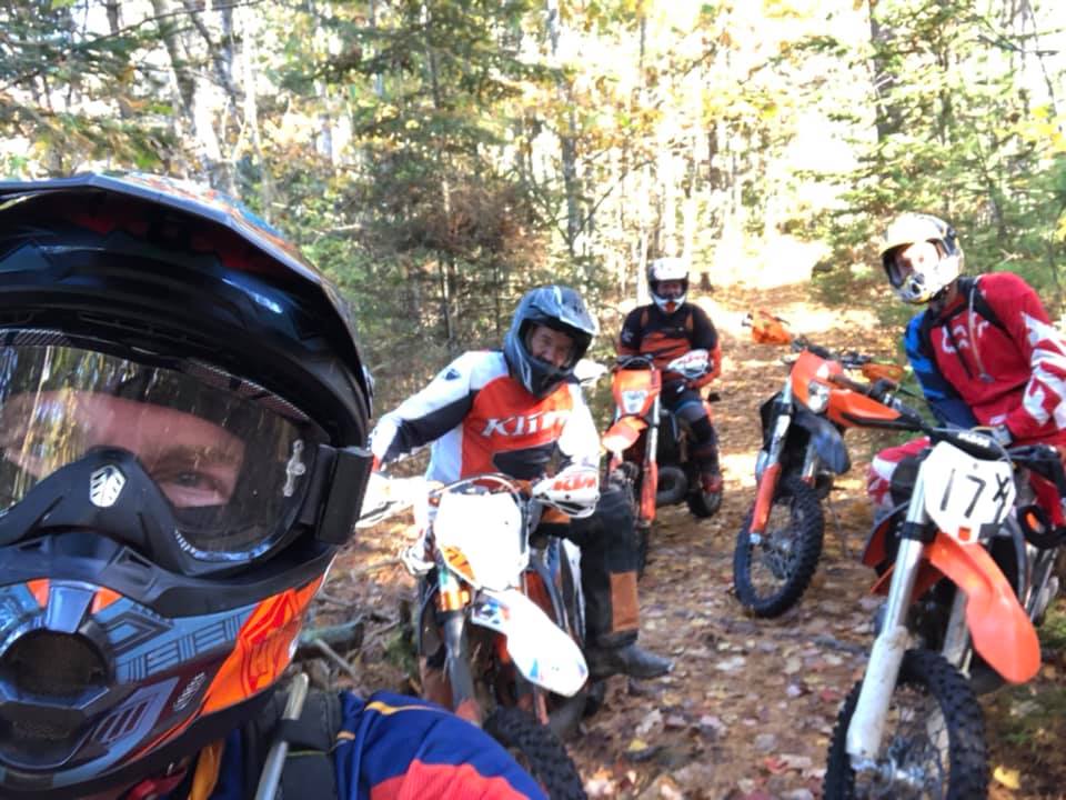 Dirt bike riders pose in the woods