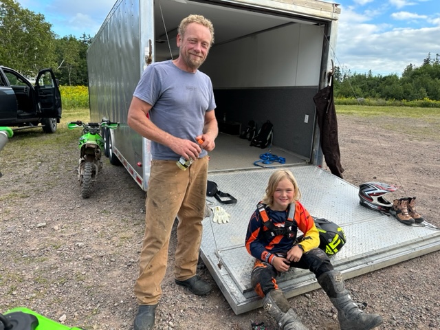 A man and a boy at a trailer 
