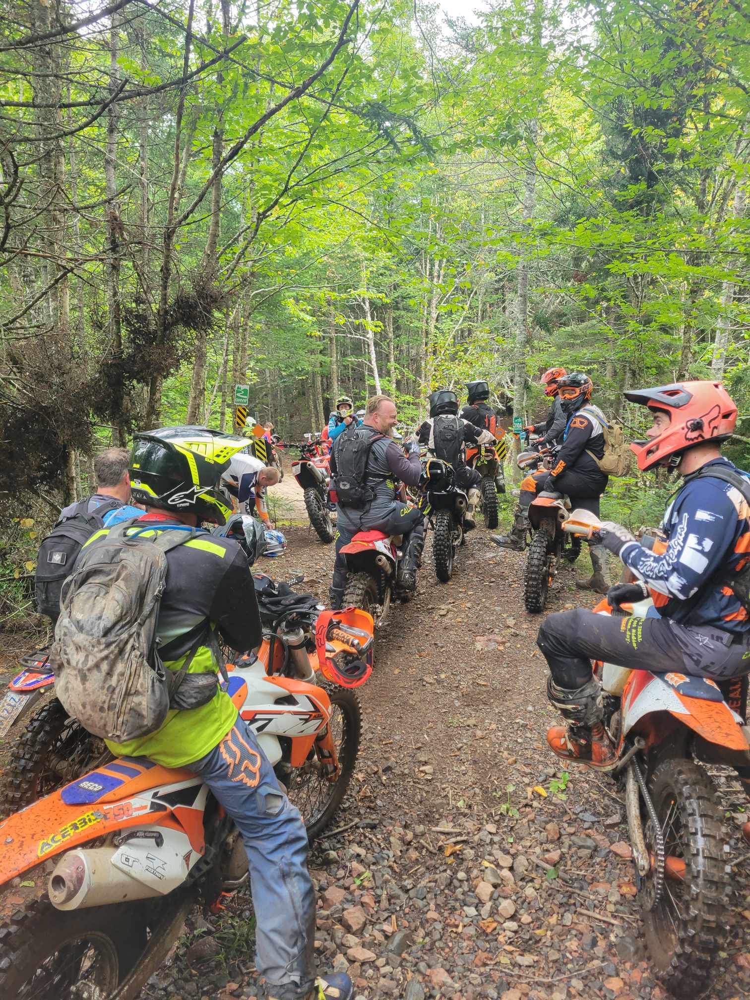 dirt bike riders lined up at the start of the trail