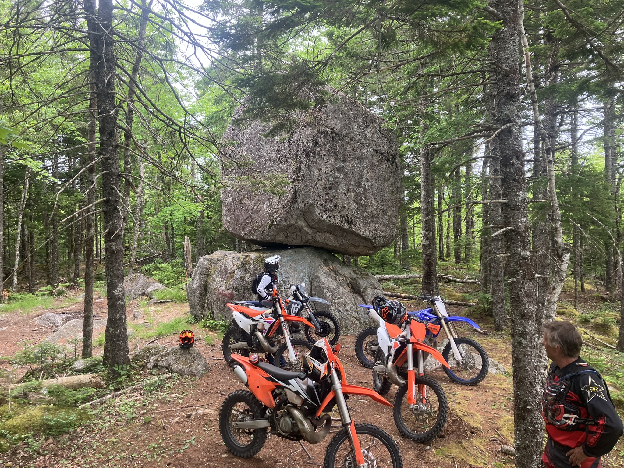 dirt bike riders check out a balancing rock in Yarmouth