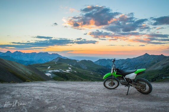 Dirt bike at the top of a mountain with sunset in the background