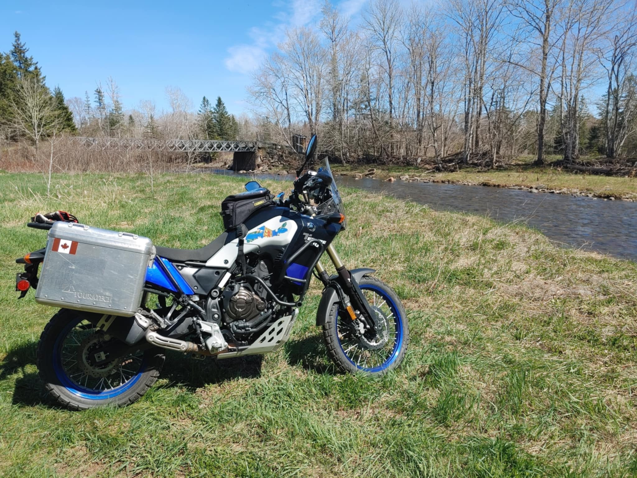 adventure bike with NS decal next to a river